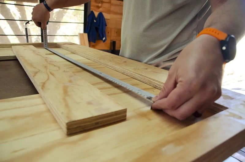 Carpenter measuring a plank on a sturdy workbench