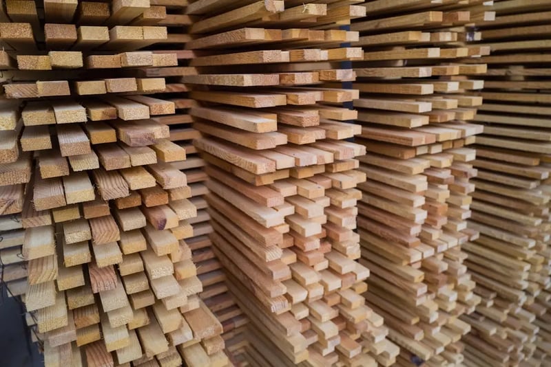 A stack of freshly cut lumber in a woodworking shop, illustrating the concept of board feet.