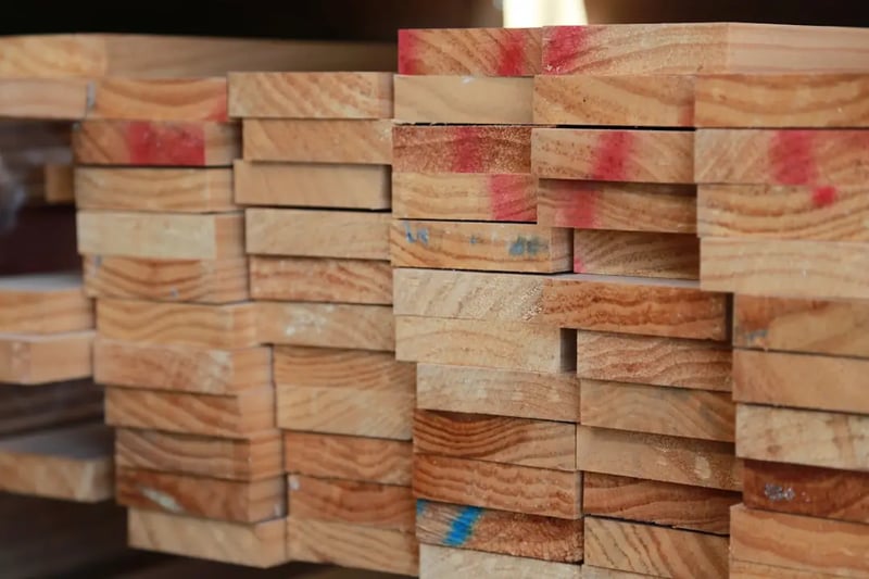 A neat stack of 2x4 lumber boards at a construction site.